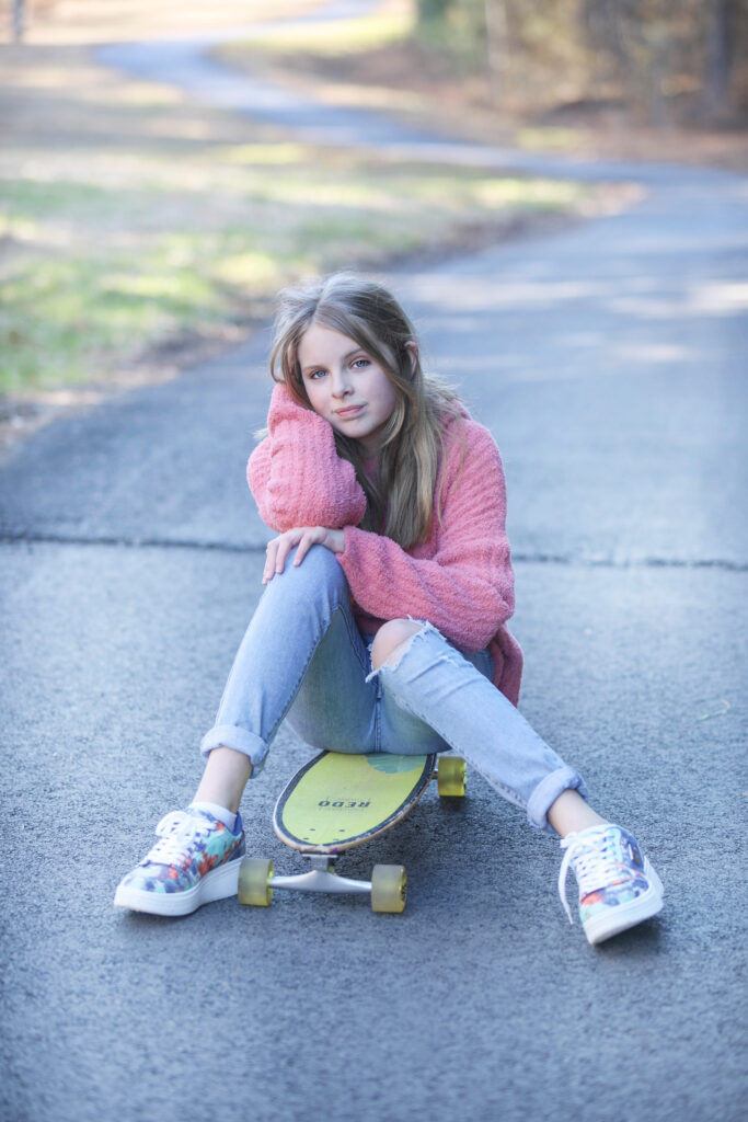 Portrait of a confident tween girl smiling during a 'Bloom Your Own Way' photo session. The image captures her radiant personality and self-assuredness, highlighting the beauty of celebrating individuality and inner strength before middle school.