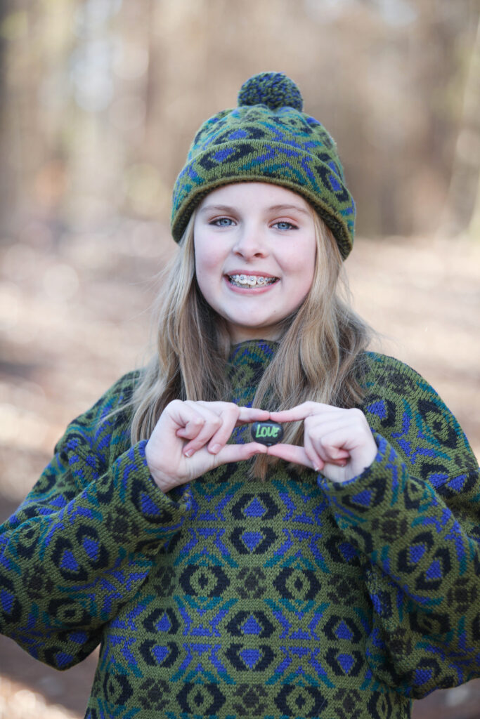 Portrait of a confident tween girl smiling during a 'Bloom Your Own Way' photo session. The image captures her radiant personality and self-assuredness, highlighting the beauty of celebrating individuality and inner strength before middle school