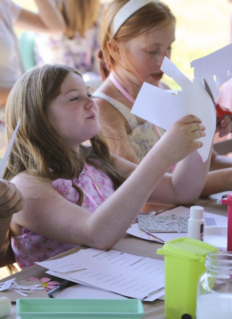 Tween girl holding empowerment art activity at confidence-building event for girls ages 9-12 in Georgia.